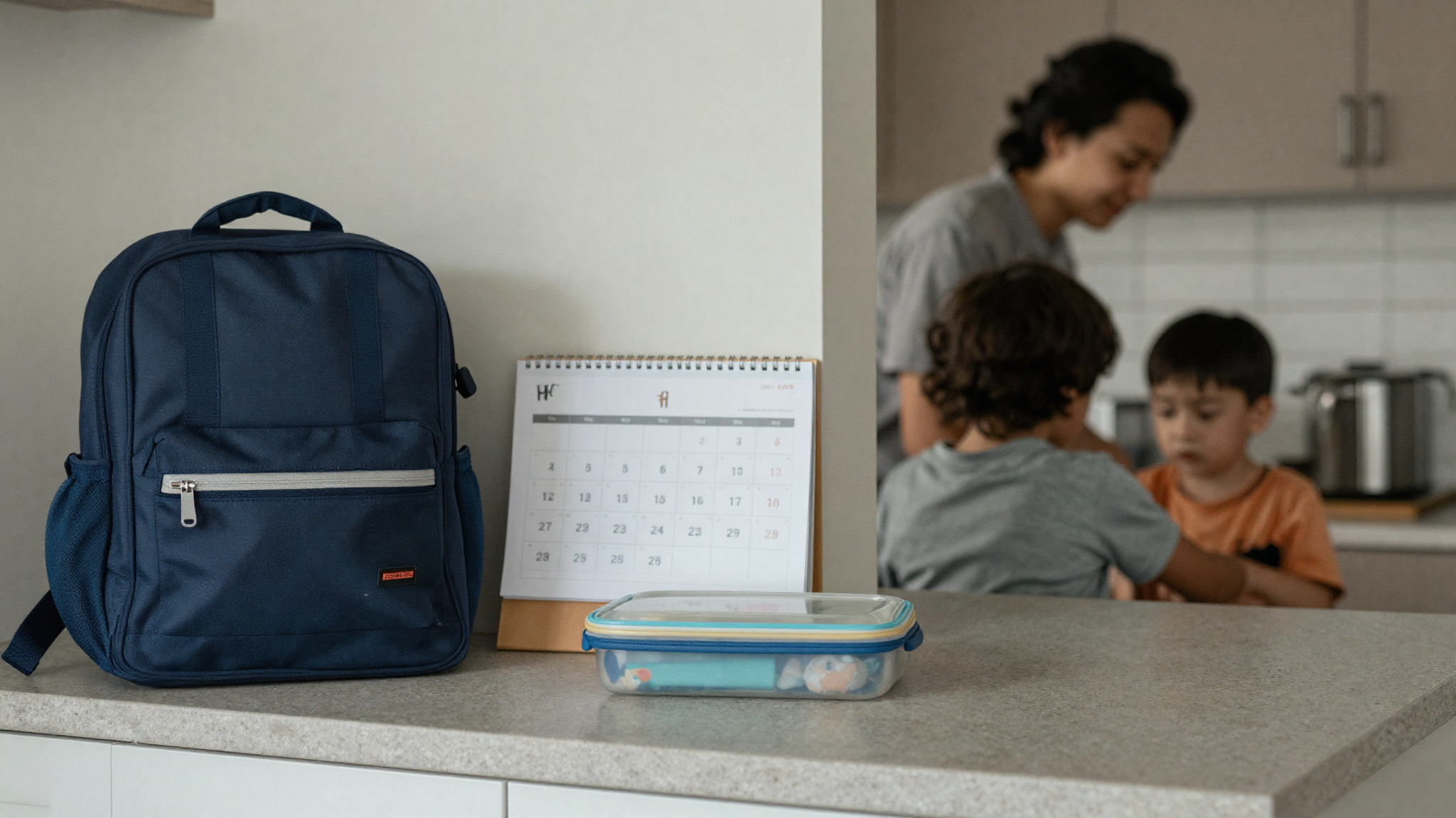 Child doing homework at a kitchen table with school papers and a shared co-parenting calendar nearby