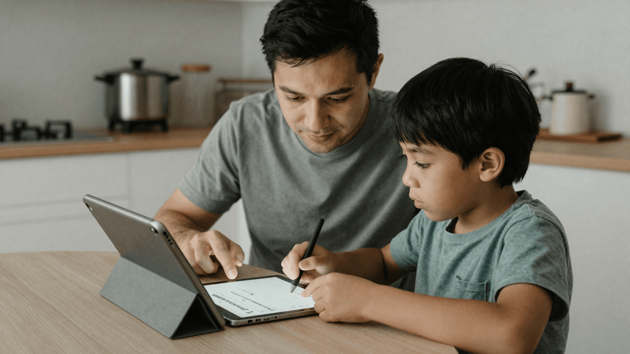 A parent and young child looking at a tablet together at a kitchen table doing a morning routine