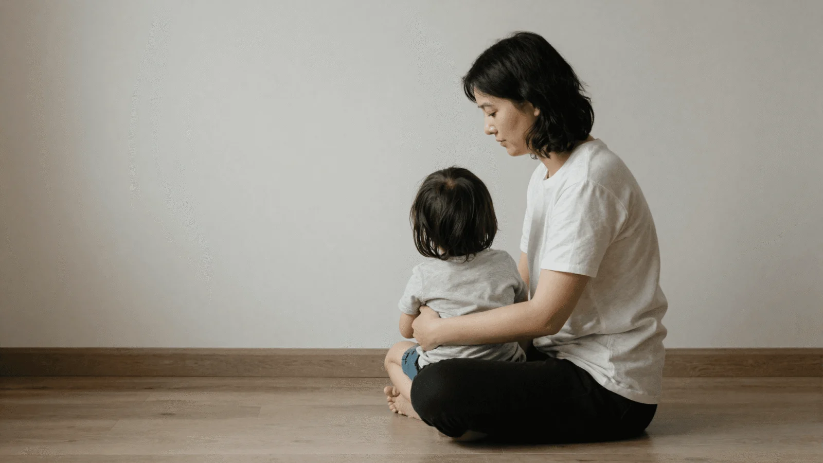 Parent sitting calmly on the floor near a child