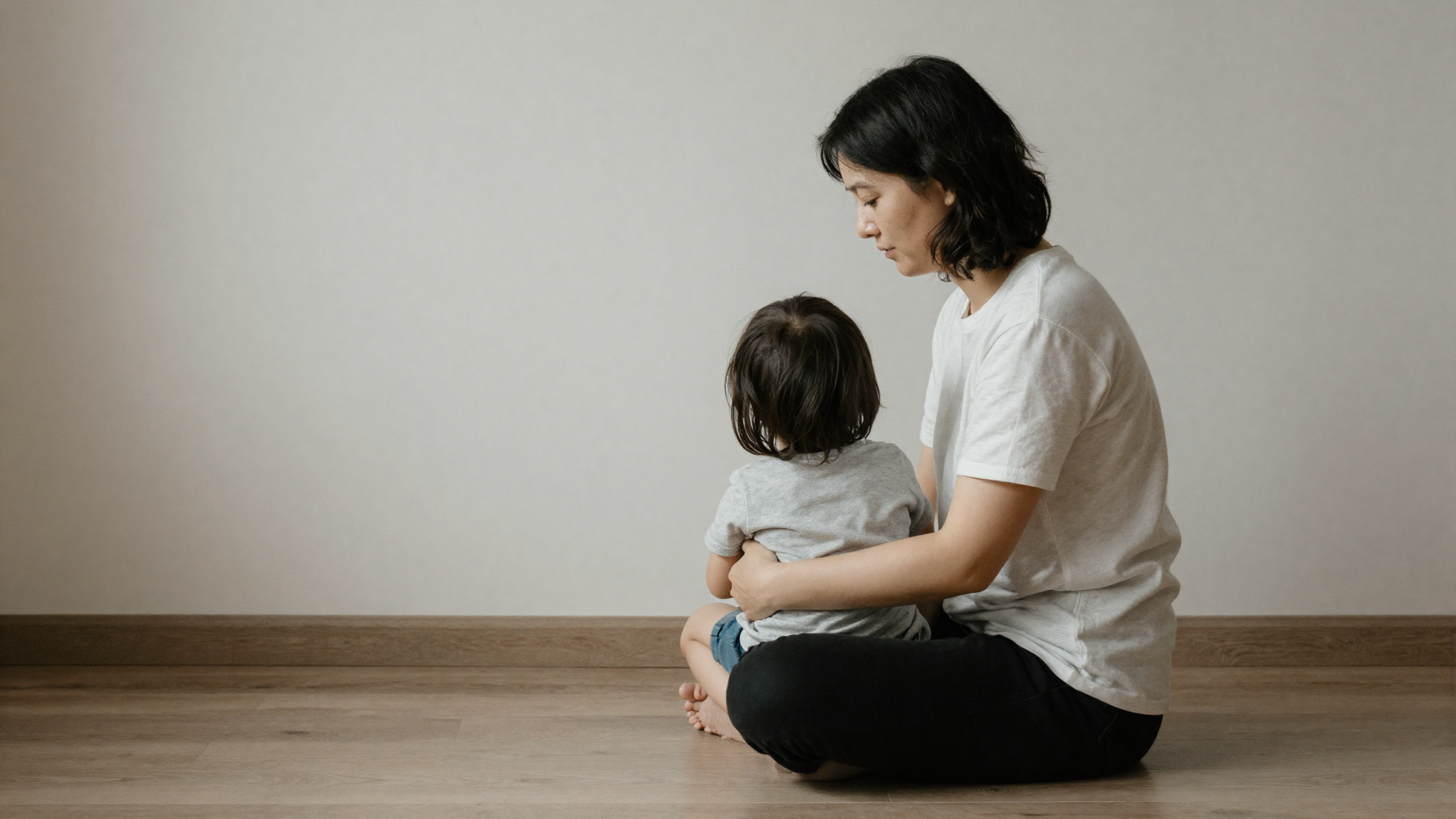 Parent sitting calmly on the floor near a child