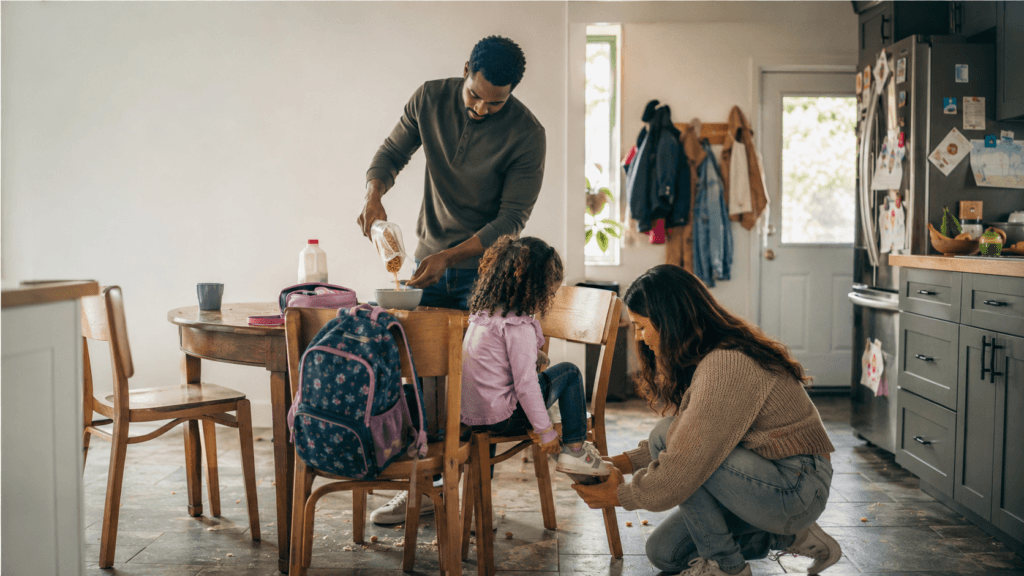 Parent helping a child with shoes during a busy school morning