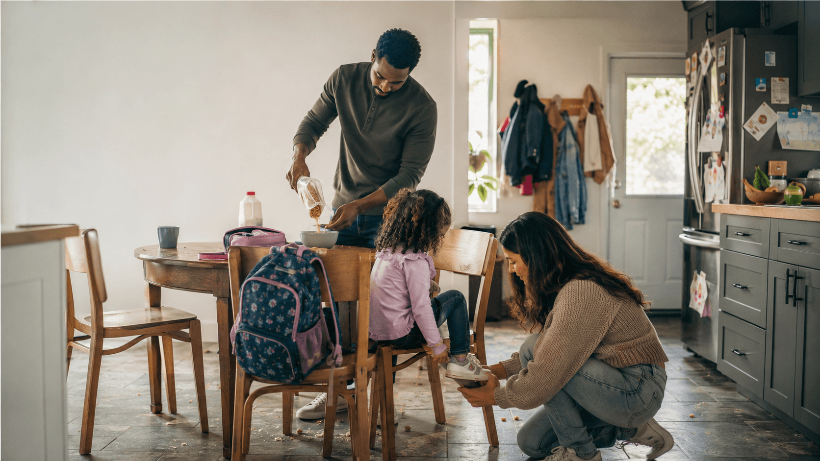 Parent helping a child with shoes during a busy school morning