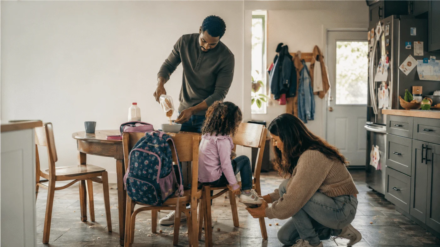 Parent helping a child with shoes during a busy school morning