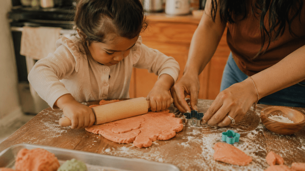 Toddler and parent using a hands-on craft activity at a table