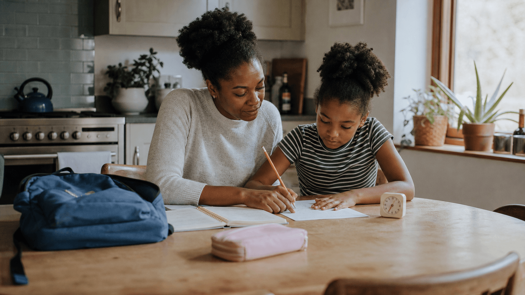 Parent and child plan homework together at a kitchen table