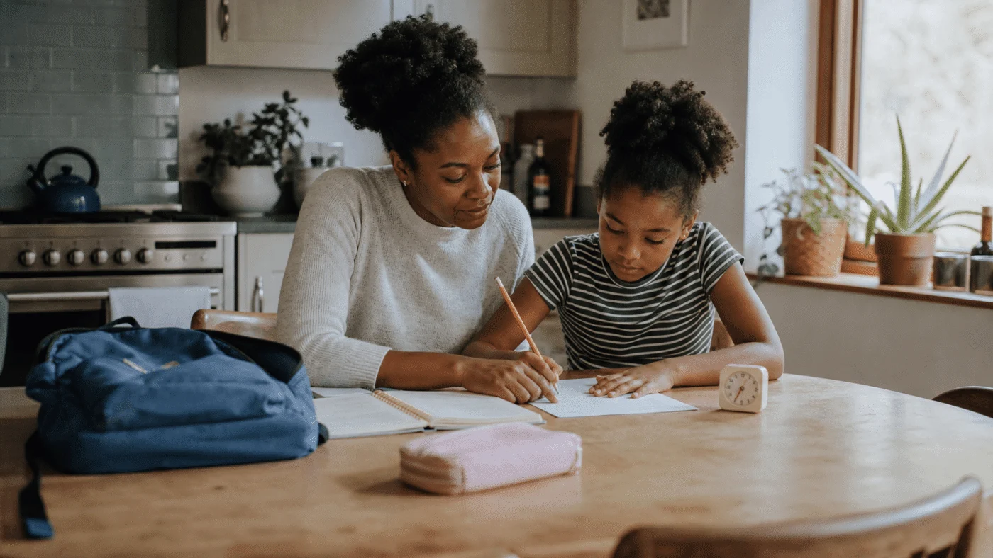 Parent and child plan homework together at a kitchen table