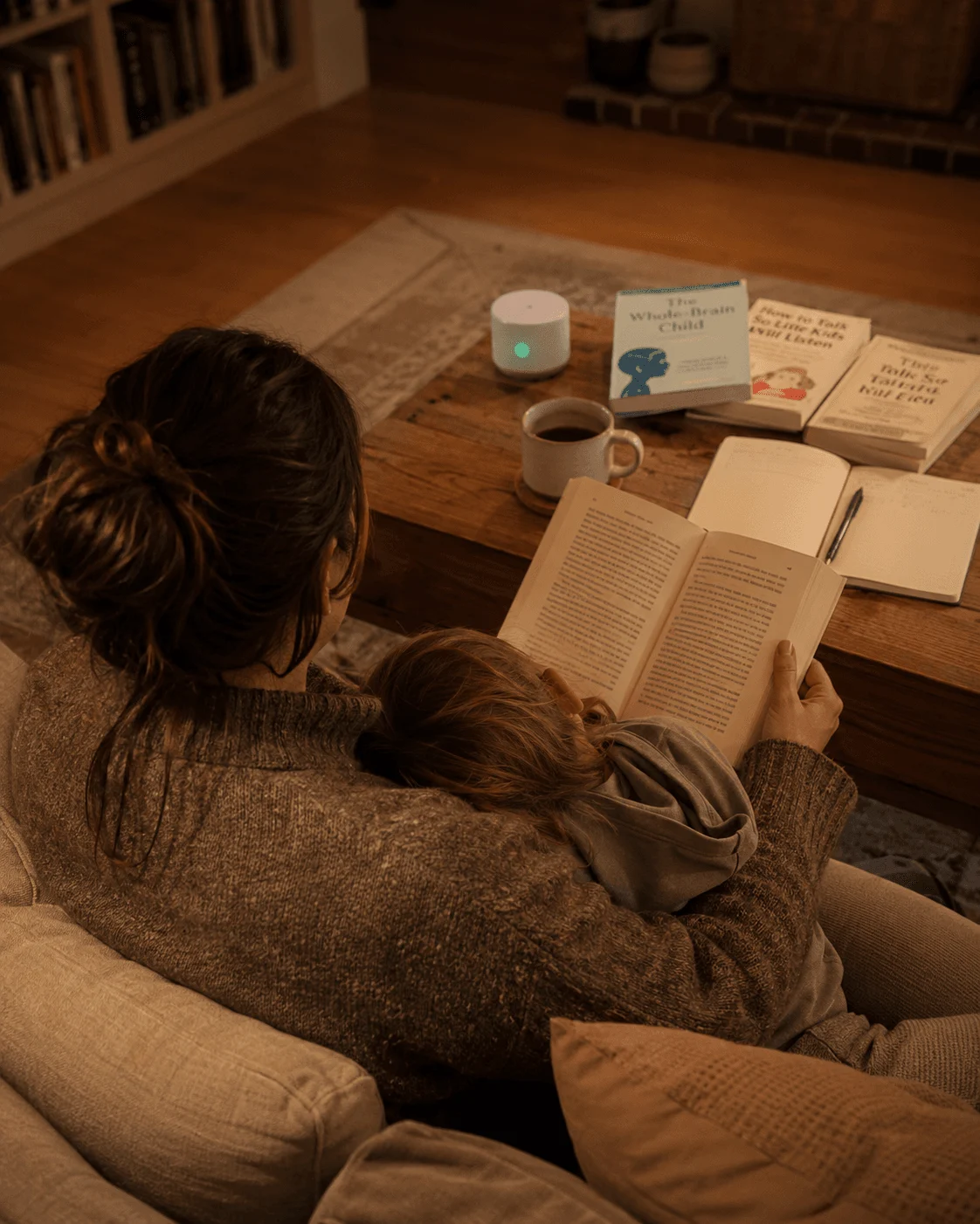 A mother and her child read together by a warm nightlight in the evening