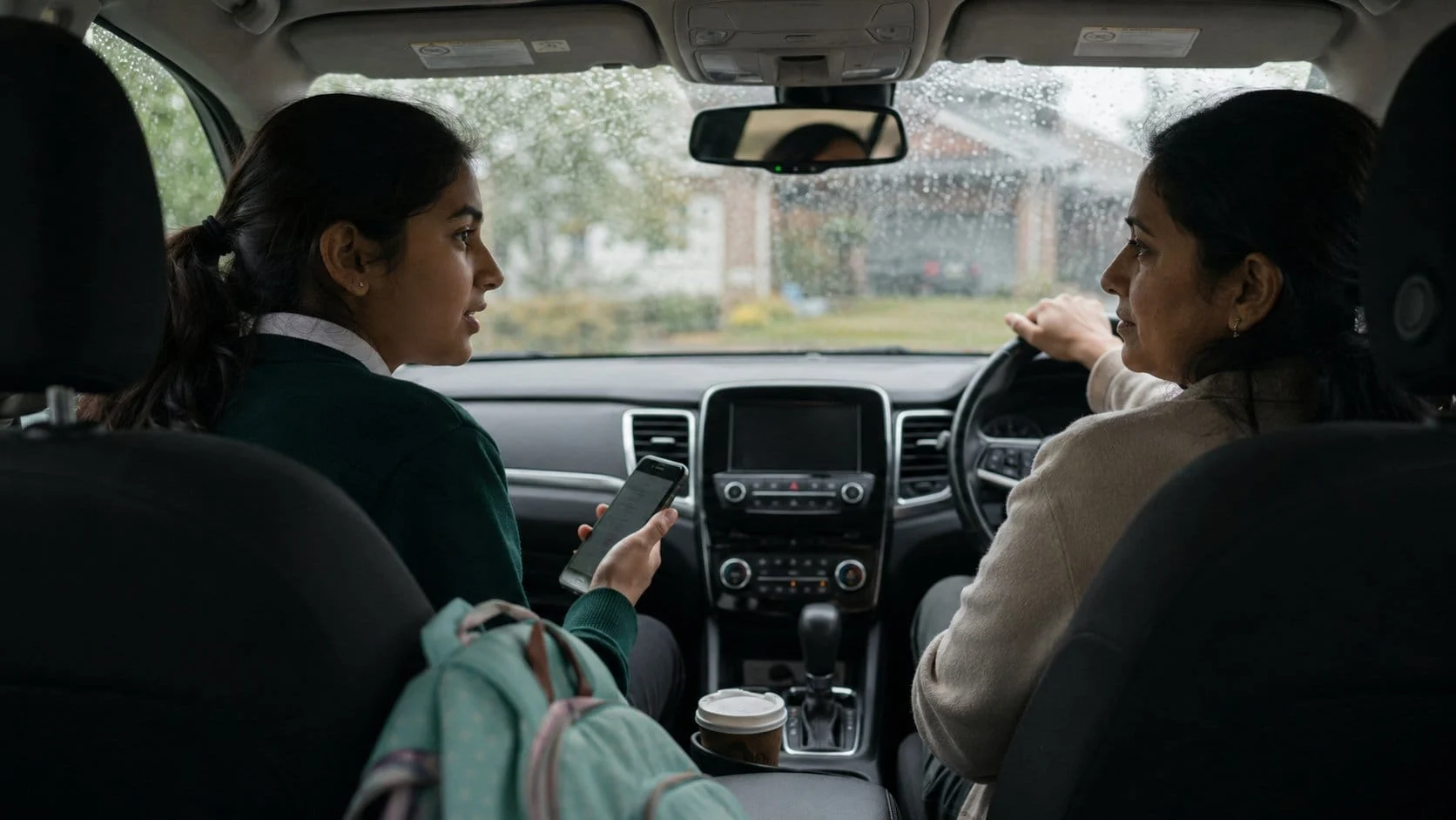 Mother and teen daughter talking in the car about screen time after school