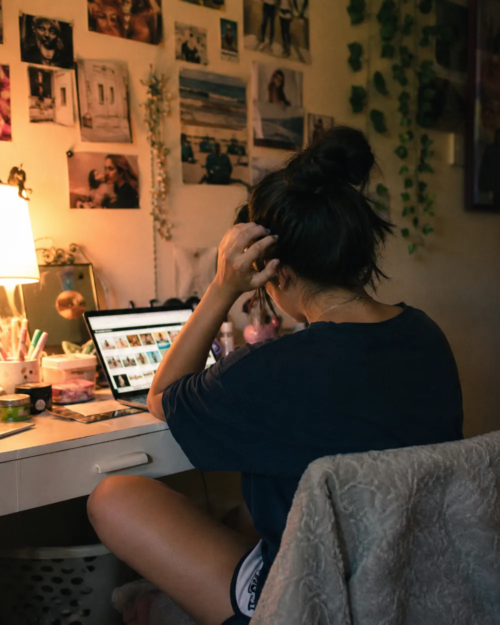 A tween bedroom desk covered in schoolbooks, headphones and personal odds and ends