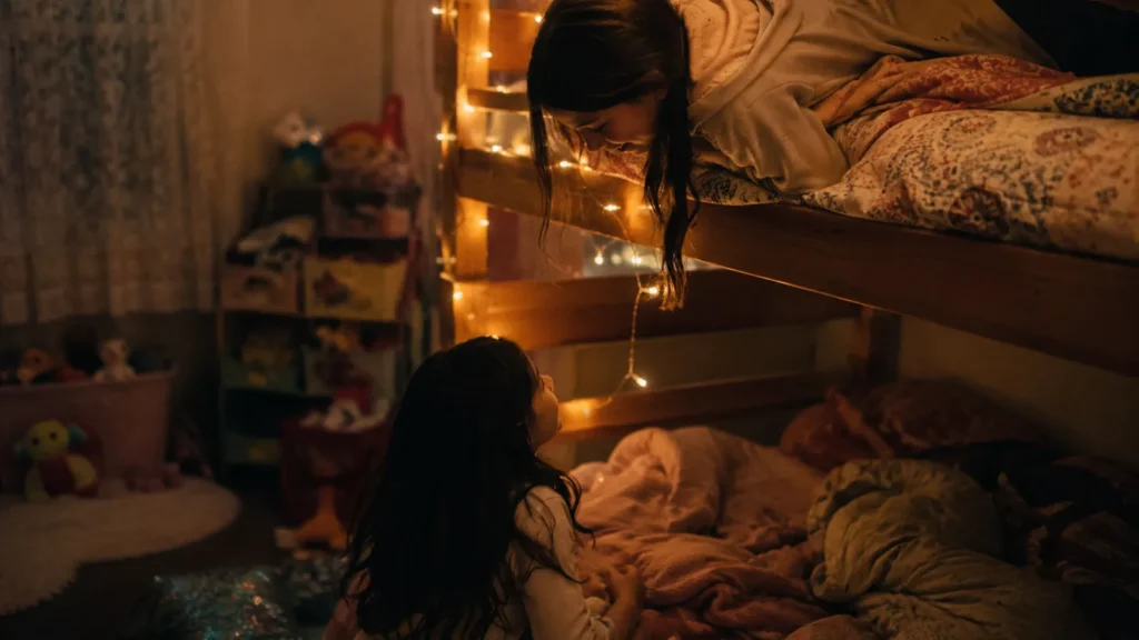 Two sisters lie awake in bunk beds at night in a shared bedroom