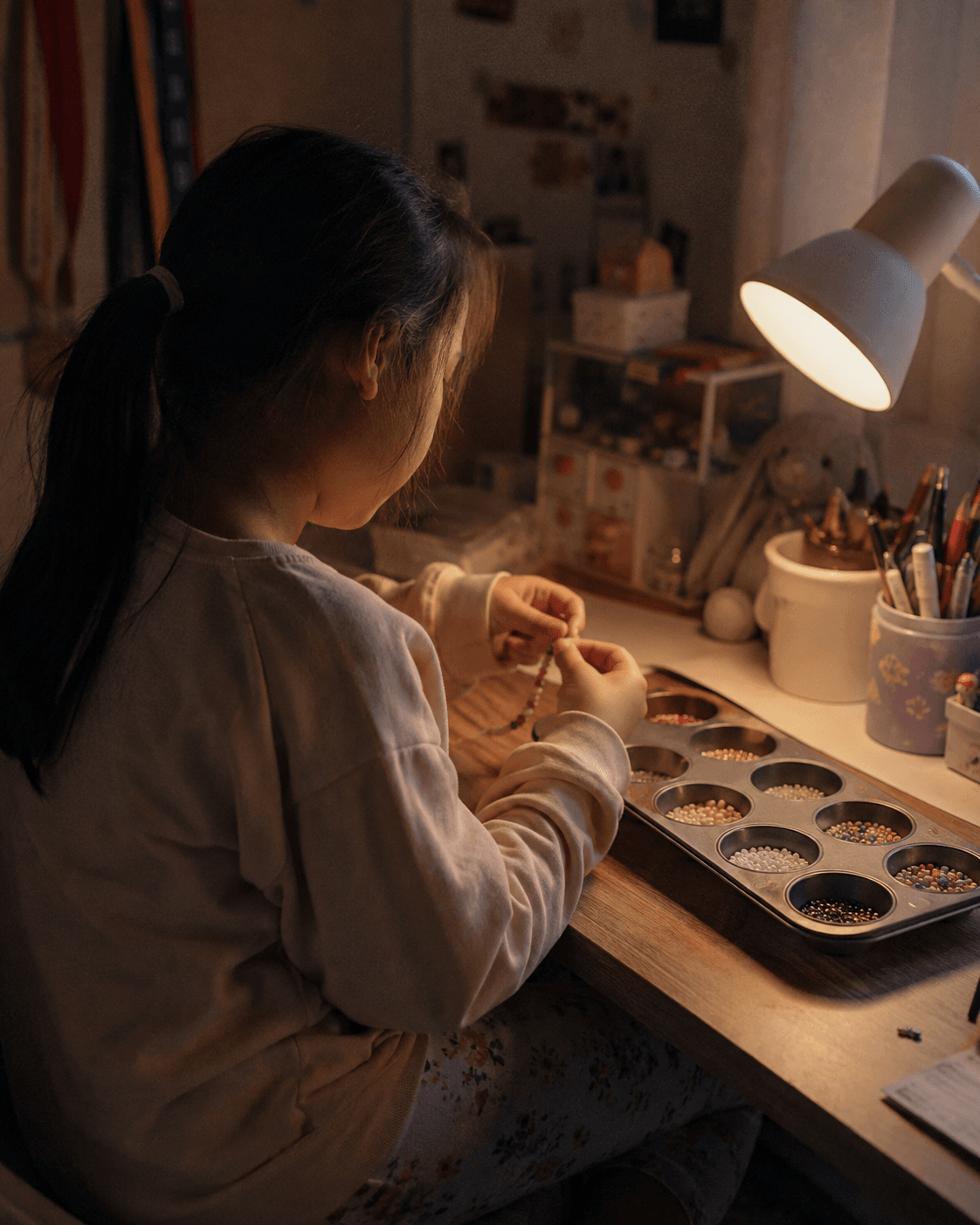 Two siblings at a kitchen table making a handmade gift together with paper, glue and ribbon