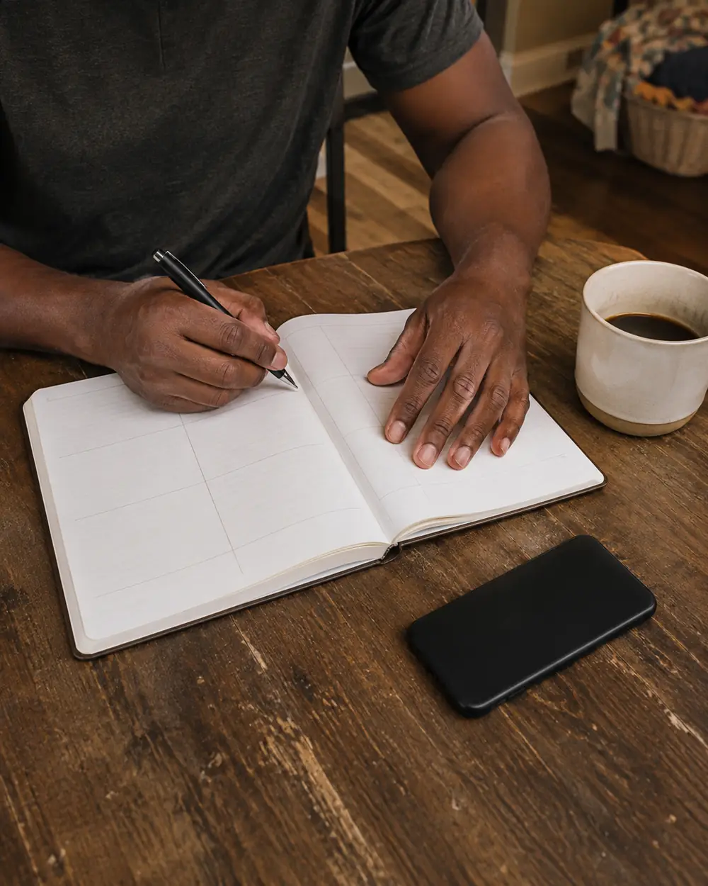 An open notebook with blank ruled pages and a pen resting on it